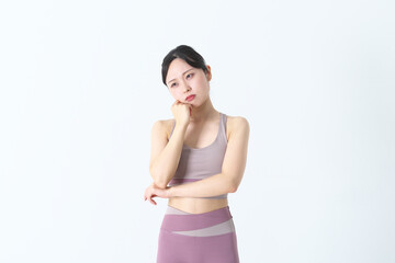 悩んでいるヨガウェアの女性