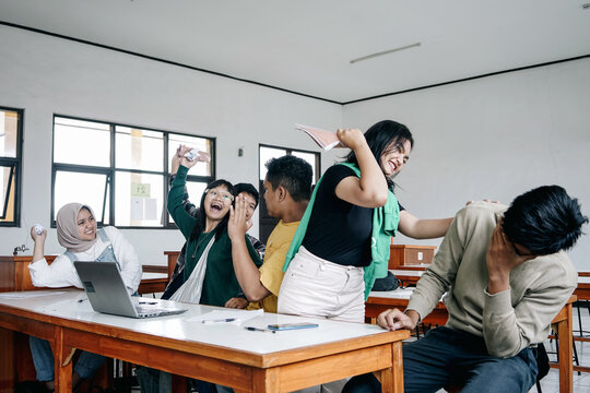 Group Of Asian Multiethnic Students Making Chaos In Classroom
