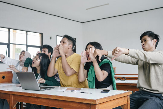 Asian students teasing and judging their classmate in classroom. Education, Bullying And Social Relations Concept 