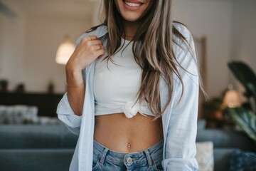 Woman smiling open shirt. Smiling woman in a blue shirt with a white top, displaying her midriff and a belly button ring.