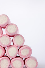 Marshmallow pyramid stack positioned to the left, photographed vertically against a white background, highlighting softness and color contrast
