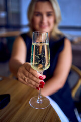 middle-aged plus size woman in old money style clothes drinking sparkling wine in a fancy restaurant