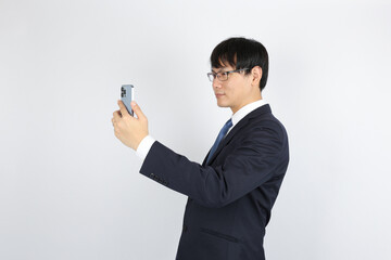 スマートフォンの画面を見るビジネスマン　テレビ通話