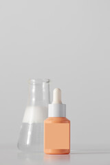 An anti-aging serum dropper with laboratory utensils next to it. Skin care.