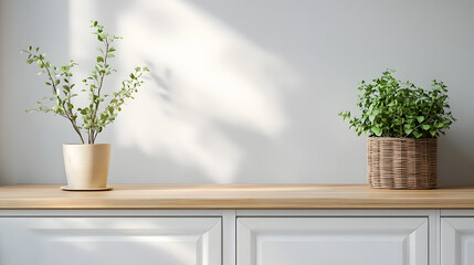 Fototapeta premium White cabinet with wooden countertop and greenery in a pot.