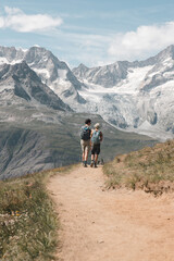 Mom and daughter walking along a rugged trail with their loyal dog