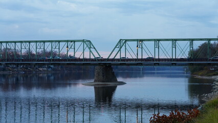 One old rion frames bridge view on the river with the sunset sky as background