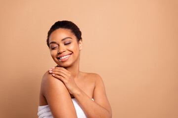Photo of stunning dreamy lady hug self enjoy bodycare bare shoulders isolated on beige pastel color...