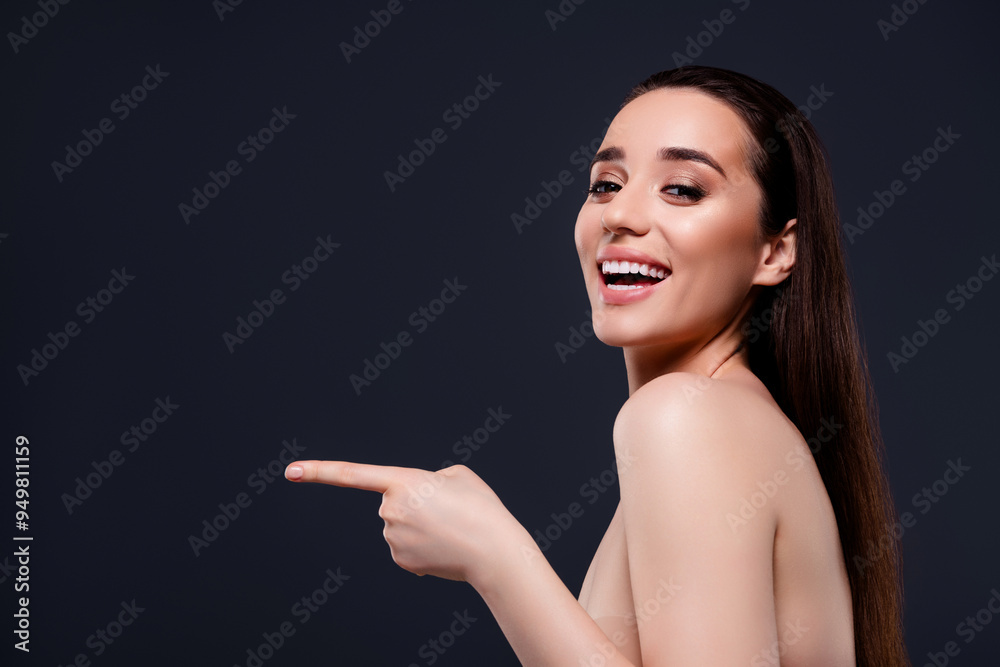 Wall mural Photo of stunning cheerful lady advertising beauty procedure empty space isolated on dark grey color background