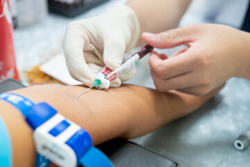 Close up hand of nurse, taking blood sample from a patient in the hospital.	