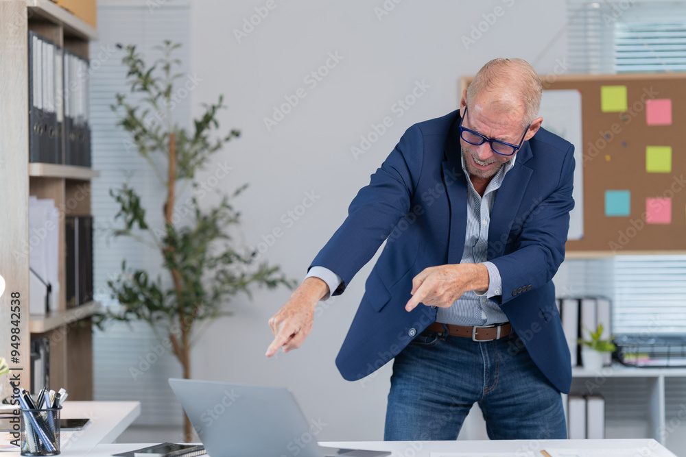 Wall mural Photo of a businessman making a happy gesture in front of a computer  on his desk at work.