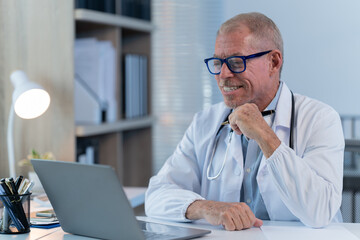 the doctor work with laptop at table in clinic. Online consultation