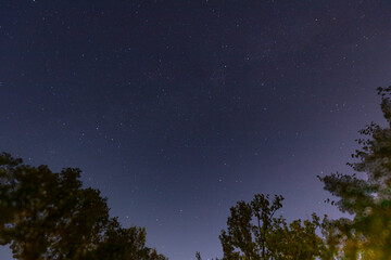 A tranquil night sky filled with numerous stars, showcasing the beauty of the cosmos. The deep blue...