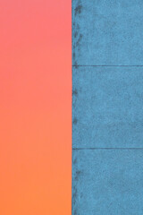 Blue and red abstract background with the wall of a house against the sunset sky during the blue hour
