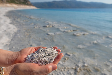 The woman is holding the white sand of Salda Lake in Turkey. maldives.