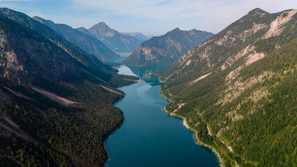 Breathtaking aerial view of Plansee Lake surrounded by majestic mountains in Austria's nature