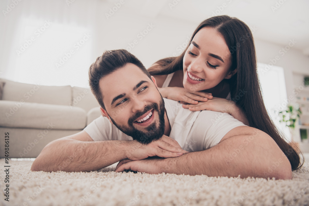 Sticker Photo of shiny cute couple dressed casual outfits lying floor enjoying being home indoors house apartment room