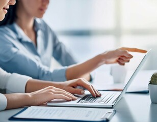 Two Women Collaborating on a Laptop in a Bright Modern Office Setting