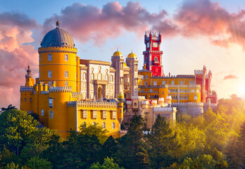 Sintra, Portugal. Palace of Pena in the National park. Lisbon. Sunrise among green trees. Beautiful fairytale castle forest pine-trees. Panoramic summer view at palace. Sunlight clouds on sky