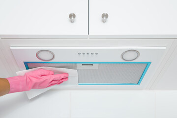 Woman hand in pink rubber protective glove holding dry white paper napkin and cleaning built-in...