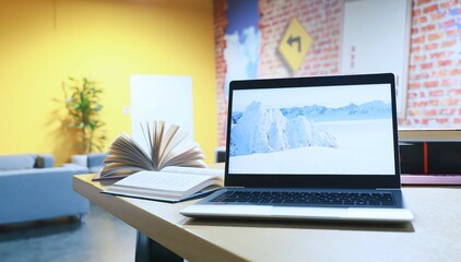 Naklejka premium open books and laptop on the table