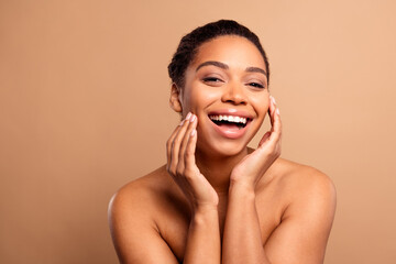 Photo of gorgeous cheerful woman lifting touch face naked shoulders isolated on beige pastel color background