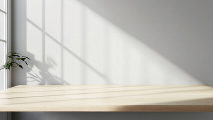 Obraz premium A light wooden table with soft shadows on the wall behind it, creating an empty space for product display or montage.