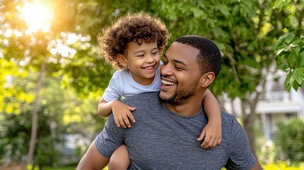 A joyful father embraces his son while both share laughter in a scenic outdoor location, making memories on a special occasion