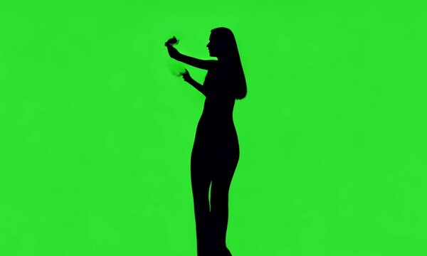 a shadow of a woman dancing on a green background