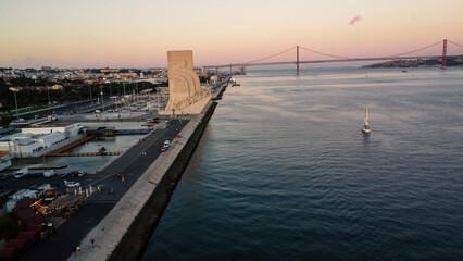 Obraz premium An aerial drone image of tagus river in Lisbon, Portugal, set against the serene backdrop of the Tagus River at sunset. Lisbon