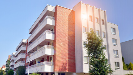 Fototapeta premium Low angle view apartment building from the beginning of the 21st century. Architectural elements of apartment building. Green surroundings of buildings. Ecological housing estate.
