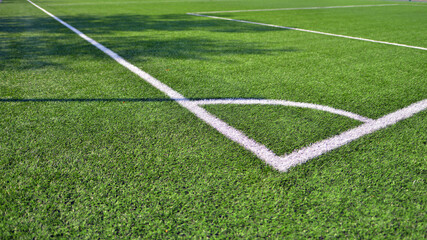 Obraz premium Artificial football turf with a white dividing line. Texture of Perfect green lawn on the football field. 