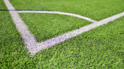 Artificial football turf with a white dividing line. Texture of Perfect green lawn on the football field. 