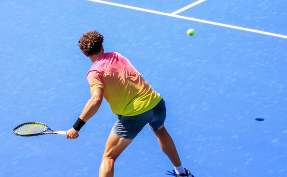 Male tennis player swinging aggressively with a strong forehand