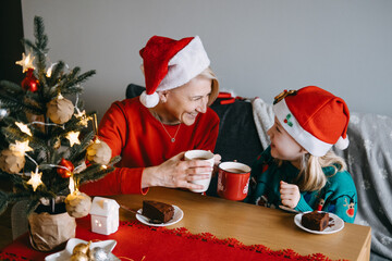 Mother and daughter enjoying Christmas treats together. Holiday desserts, festive food, family...