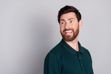 Photo of glad cheerful positive man wear stylish green clothes look empty space isolated on gray color background