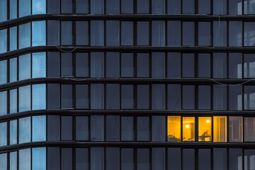 Abstract texture with windows of a new office building during the evening work of a workman