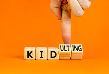 Kid or kidulting symbol. Concept words Kid or Kidulting on wooden cubes. Beautiful orange table orange background. Psychologist hand. Healthy lifestyle and kid or kidulting concept. Copy space.