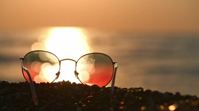 Sunglasses on the background of the sea at sunset, concept summer vacation at the sea