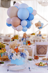 Setting and decorating tables for a children's party in the banquet hall. Balloons and teddy bears...