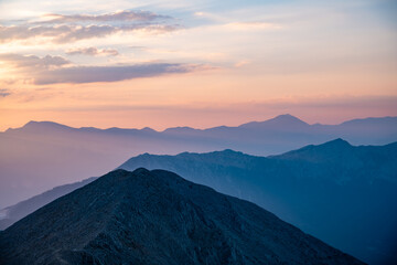 Silhouettes of mountains in a beautiful gentle haze, mountains at sunset or sunrise, natural background