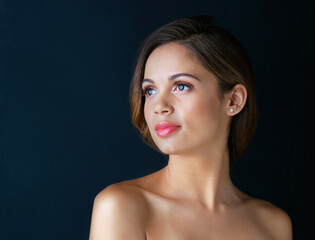 Woman, thinking and skincare on black background in studio, ponder glow and cosmetics or makeup. Female person, mockup space and reflection on clear dermatology, treatment and balance in skin tone