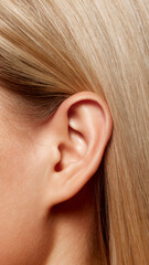 Close-up of female ear and blonde hair. Plastic surgery, medicine, aesthetics, otoplasty concept....