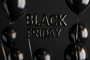 Black friday text formed by metallic balloons floating on a dark background