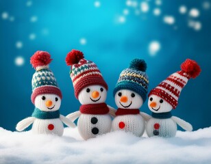 little knitted snowmans on soft snow on blue background