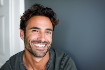 Attractive young man with a big smile on his face. Handsome adult with cheerful and positive expression. Confident and healthy looking person posing for the camera in casual attire.