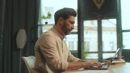 Handsome man sitting at desk open laptop look on screen typing in office. Work time. Camera moving around. 360 Degree