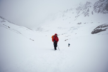 Male mountain climber on top of snowy peak.