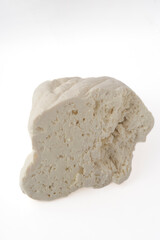 Piece of sheep or goat cheese isolated on white background.