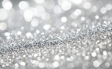 An abstract background with blurred shiny silver bokeh, with white bokeh on a grey background.